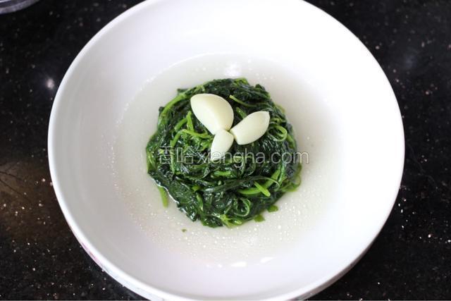 等到苋菜烧熟就可以捞出来了，然后在苋菜周围浇上大骨头汤汁，再摆上大蒜头，做造型