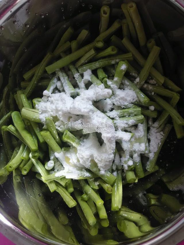 把豆角倒进盆里调入食用油，生粉，和少许盐拌匀。