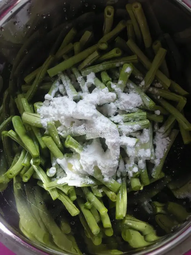 把豆角倒进盆里调入食用油，生粉，和少许盐拌匀。
