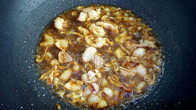 调入生抽、料酒翻炒至肉片上色。