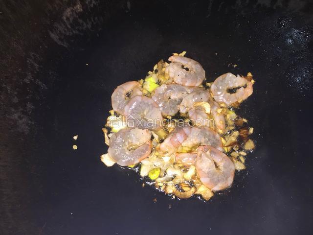 热锅中加入一勺油，（虾仁在入锅前加入一点点油抓散）放入葱姜随即把虾仁倒入锅中炒散翻匀