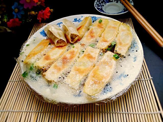 用盘子盖上锅贴，倒扣出来