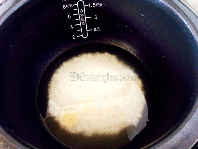 把米洗干净，加适量的清水和两滴香油浸泡十多分钟。