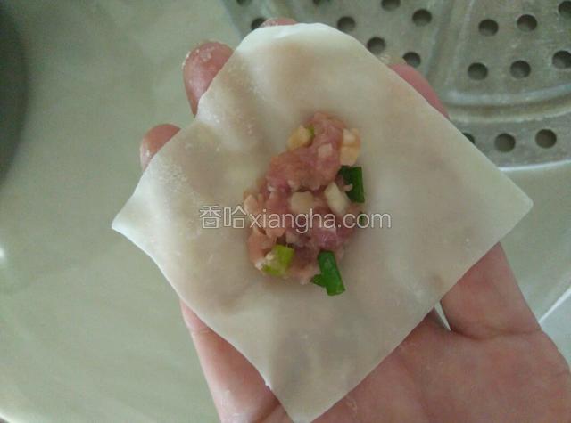 开始包抄手，取一小团肉放置于抄手皮中间，四角沾点水。