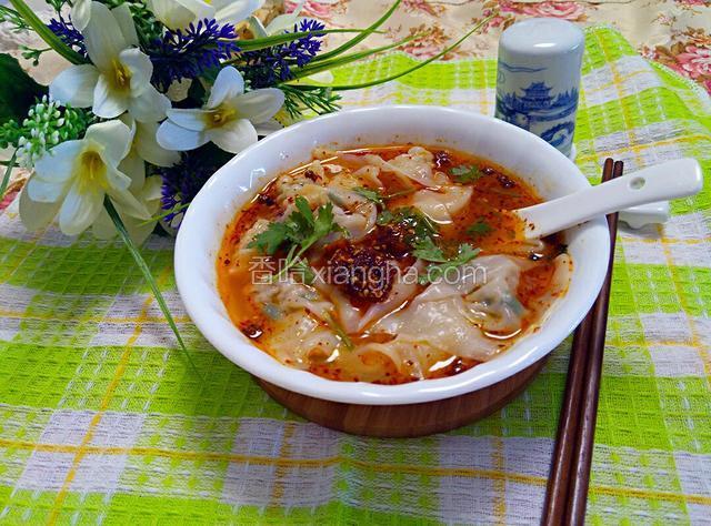 再把煮好的抄手倒入碗中，撒上香菜碎，再加一匙油辣椒更过瘾。