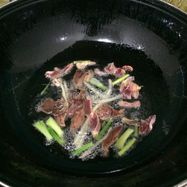 锅里油热，放姜丝葱段爆香，再放入鸡肝鸡胗。