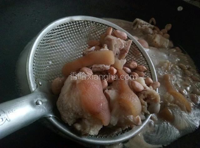 待锅中的水煮制沸腾，捞起猪脚。
