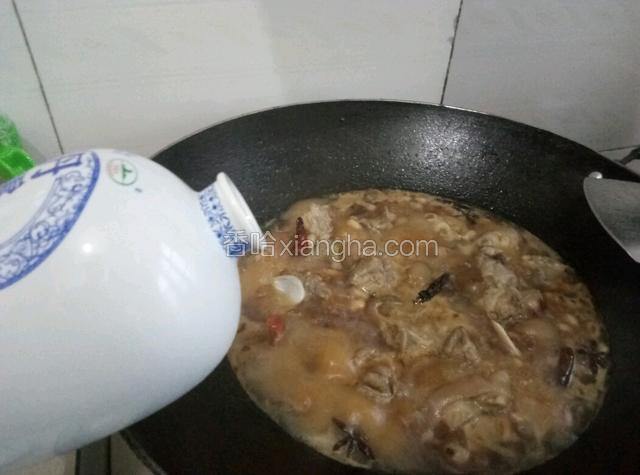 在往锅中倒入适量的白酒。