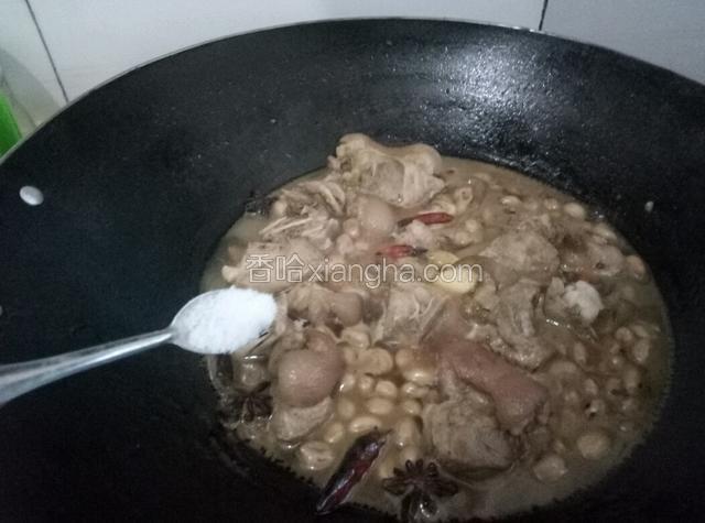 往锅中倒入适量的盐。