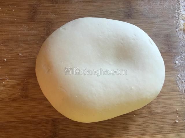 面包撒薄粉，取出面团，揉至面团表面光滑。