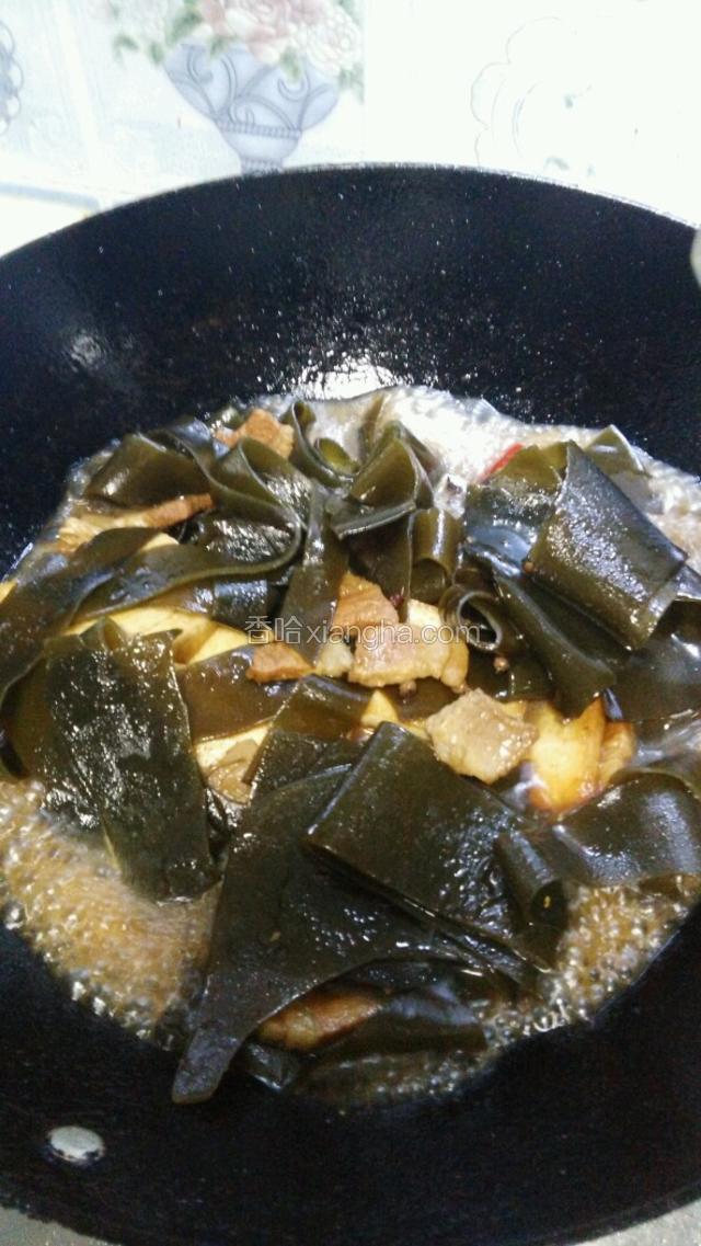 翻炒均匀后，倒一些凉开水或高汤，要没过海带，依次加入香叶八角生姜，大火烧开后盖上锅盖小火慢炖三十分钟，炖至肉酥烂，加点冰糖，点小半勺老抽提色，待汤汁浓稠便可出锅了