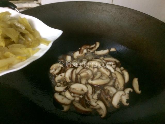 翻炒至香菇变软后加入酸菜丝继续翻炒。
