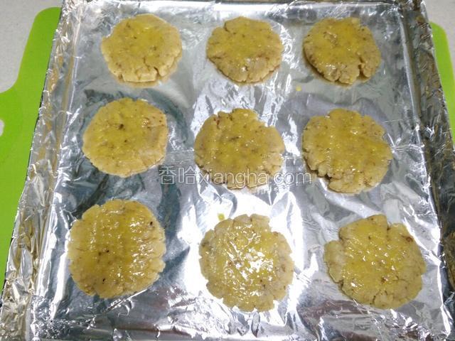 取二十克左右面团搓捏成圆形后压扁放入铺好锡纸的烤盘，面团压薄一点，这样容易烤透。同时设置上下火170度预热。