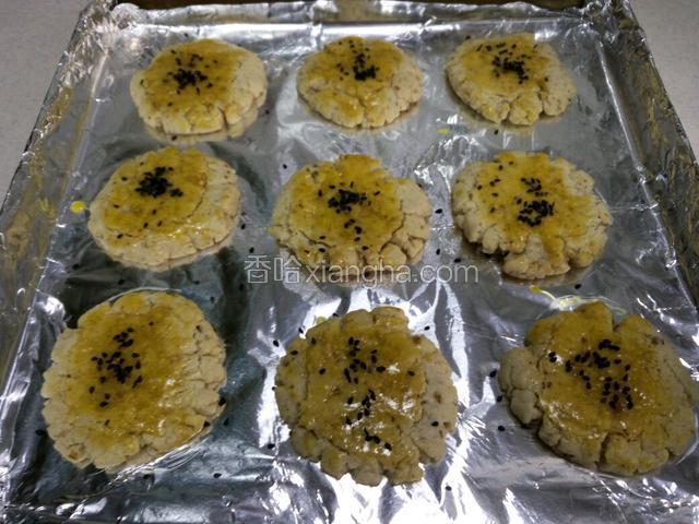 在做好的核桃饼上刷一层蛋液，撒上适量的黑芝麻。