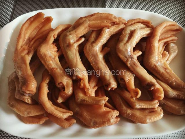 鸭脚捞出摆盘、把辣椒放在鸭脚上面倒入调好的凉拌酱汁浇入鸭脚上面即可
