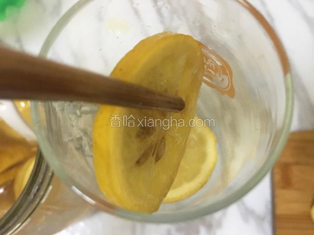 用干净无水的筷子从密封罐中夹出两片柠檬