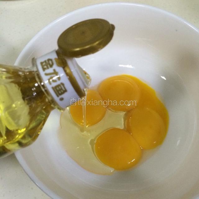 在蛋黄内加入玉米油，搅拌均匀。