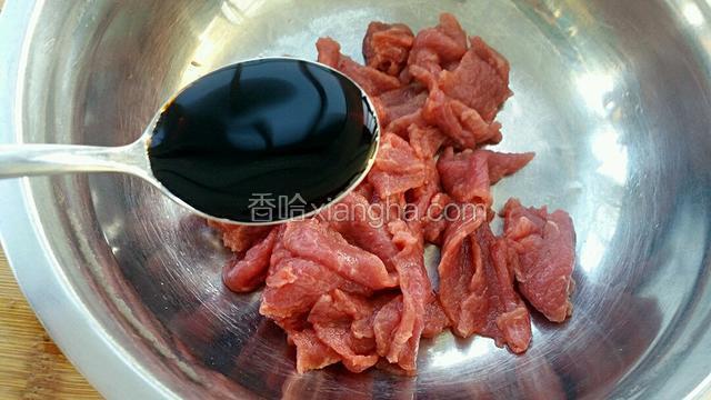 把牛肉切薄片放入一大勺生抽。