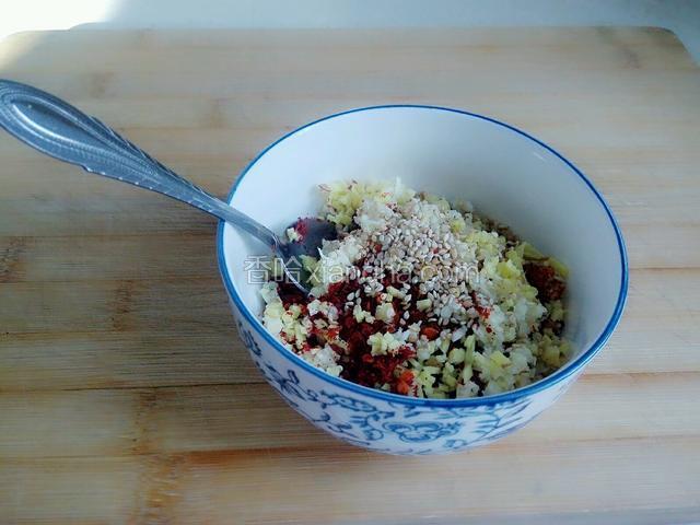 把姜蒜末放辣椒面上面，然后加入少许盐，最后撒上白芝麻。