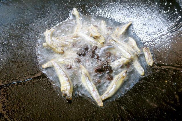 锅里热油放入鱼小鱼仔和豆豉爆炒。