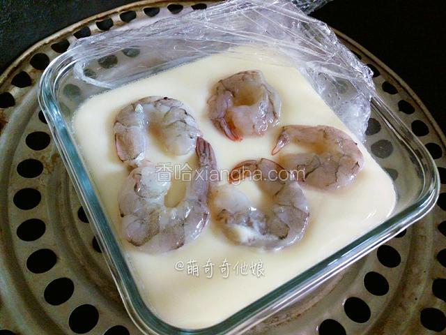 揭盖揭开保鲜膜放入虾仁，盖好保鲜膜加盖继续蒸1-2分钟即可。
