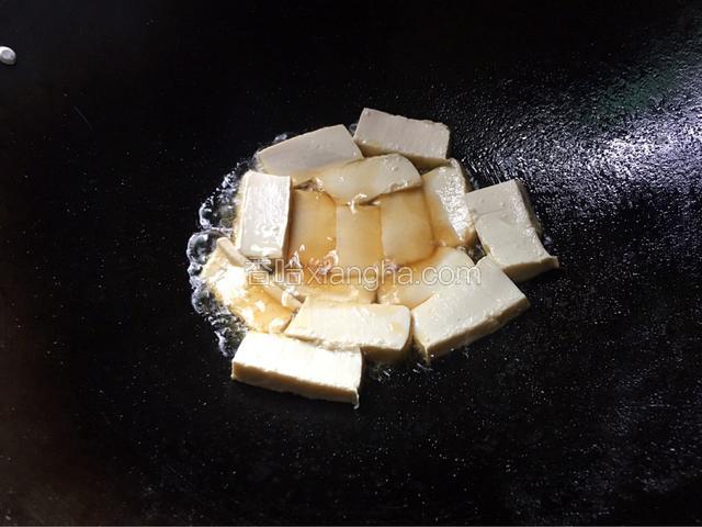 锅中烧热油，把豆腐切小块放入去煎