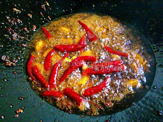 底料快融化的时候倒入红辣椒，调入料酒，蚝油炒香。