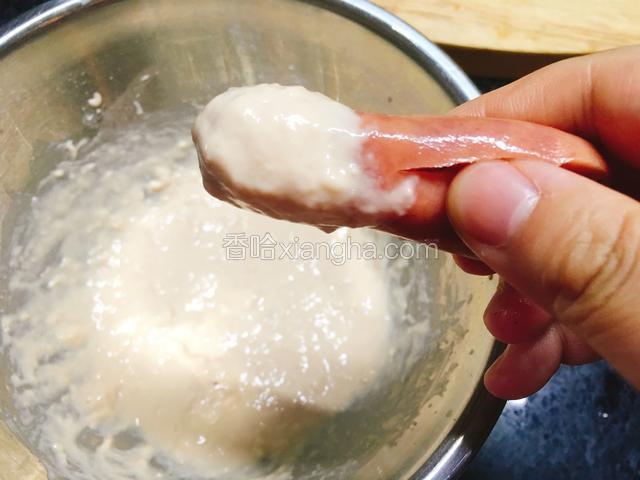 抓住“章鱼”脚，把香肠连着那头放入面糊中滚一圈。