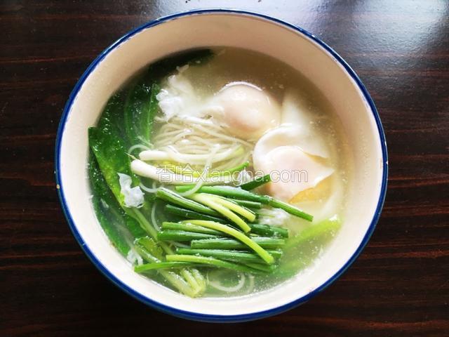 装碗。先挑起面条，再盛出鸡蛋和青菜。最后加入葱段。