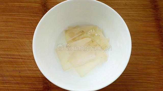 吉利丁片放进小碗中，倒入牛奶泡软。