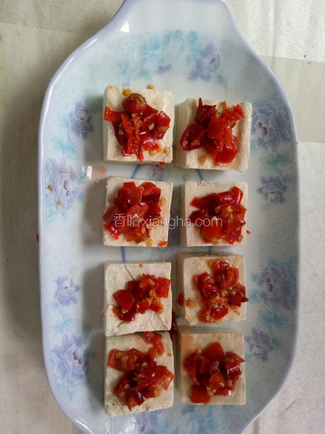 每块臭豆腐上面放上剁椒。