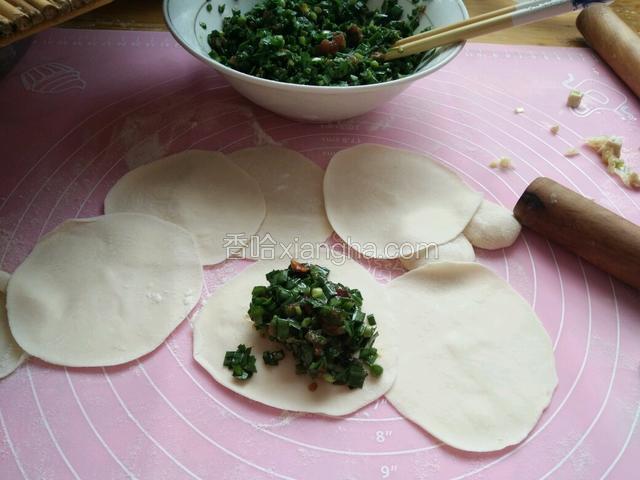 然后擀饺子皮，放上韭菜馅包饺子。