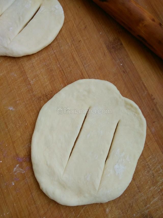 把小面团揉圆按扁擀成饼坯，中间划两刀，不要划断。