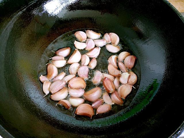 锅中烧油下蒜瓣炸制