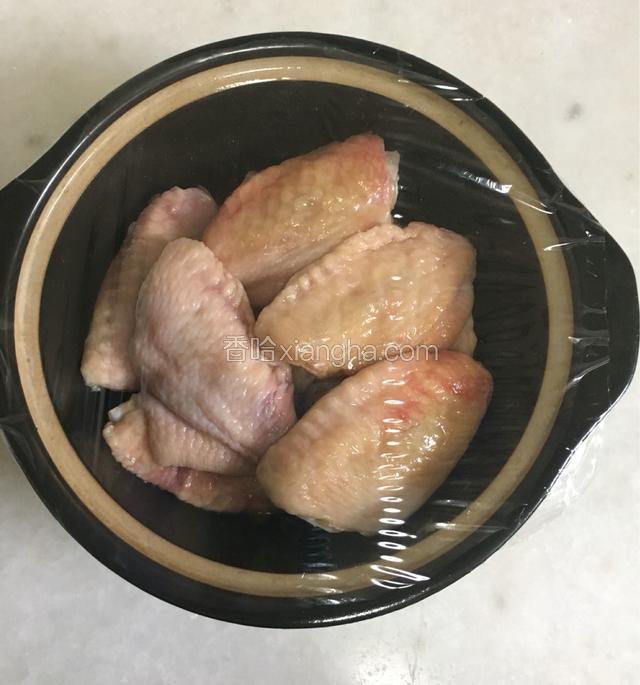 用半包焗鸡粉将鸡翅均匀涂抹后，蒙上保鲜膜放入冰箱冷藏2小时以上腌制入味