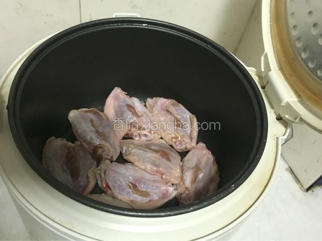 鸡翅挨个平放入锅里盖上盖子，按下煮饭键