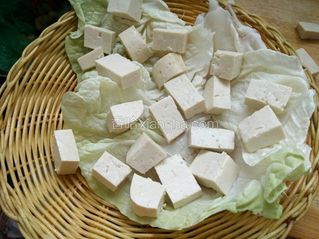 把豆腐放在小篦子上，篦子上必须铺一层干净的白菜叶，或者是玉米叶。