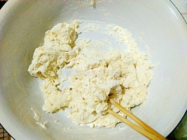 一点一点的往面盆里倒水，用筷子搅拌成絮状。