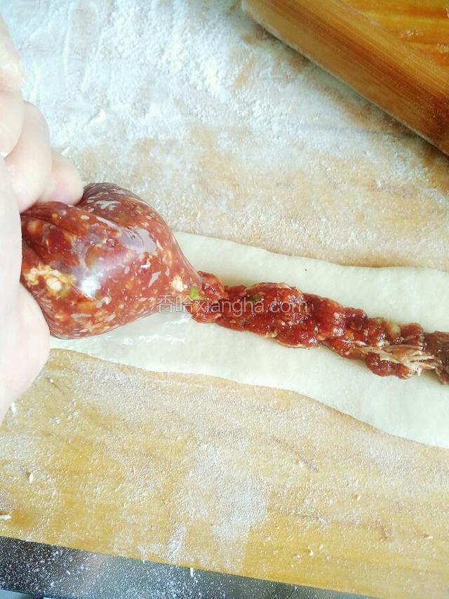 从保鲜袋开口处挤出肉馅，挤在面的中心部位。