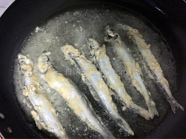 平底锅倒入适量油烧至六成热时放入多春鱼，小火煎至金黄色