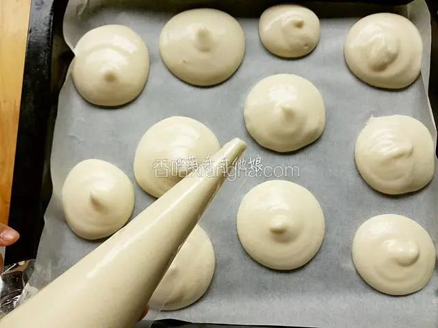 将拌好的蛋糕糊倒入裱花带中，剪个小口子，在铺了油纸的烤盘上挤出一个个○形蛋糕糊。