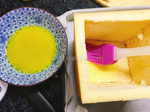 用刷子在吐司底部、内边上涂抹一层蜂蜜酱。
