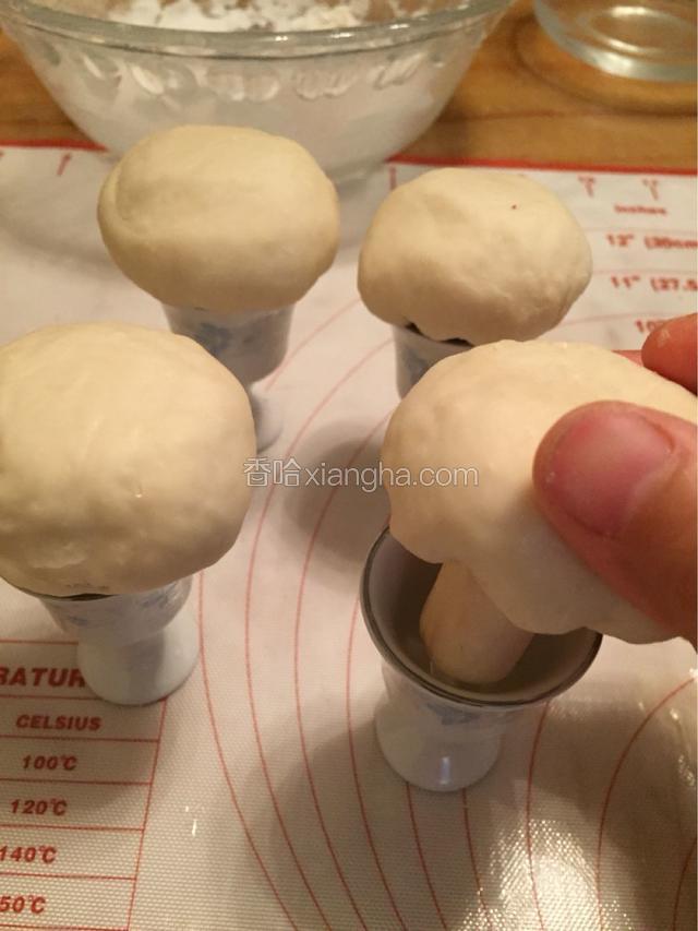 在将包好的香菇包放入刷上油的酒杯中