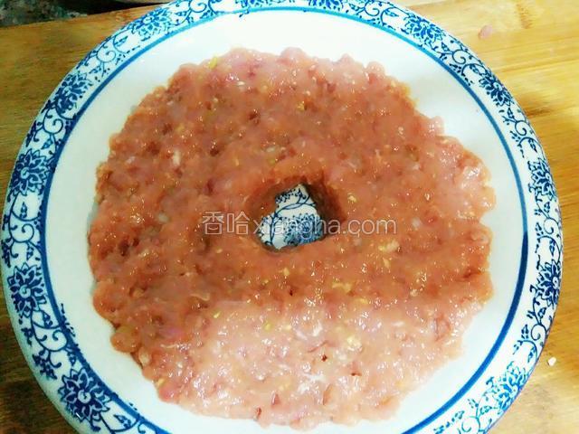 准好一个盘，把肉馅平铺在盘底，中间留个孔，一会注水