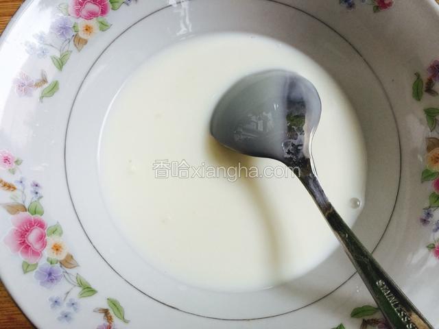 舀一半牛奶，给牛奶里加入一勺炼乳搅拌均匀。