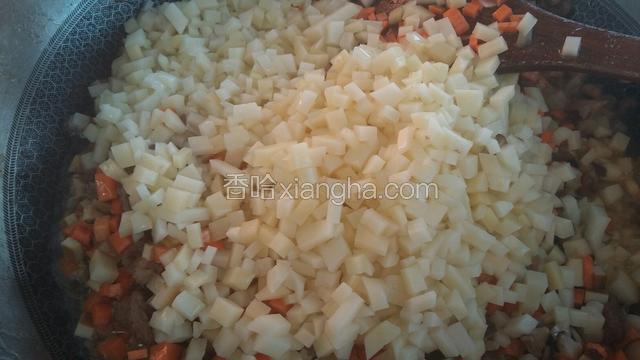 接着倒胡萝卜丁，土豆丁，香菇丁，豆腐干丁，翻炒。