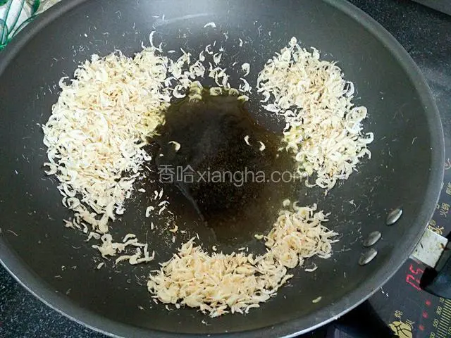 然后将虾皮移到锅边，把大豆油倒入锅中间烧热。