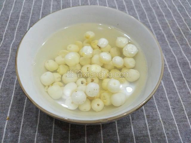 将莲子洗干净用开水泡开。