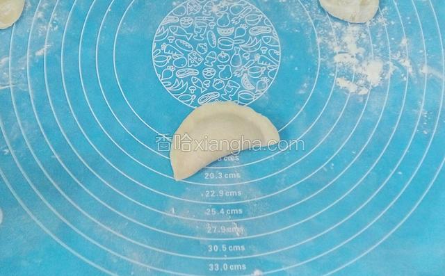 饺子皮对折后将边沿捏合成月牙状