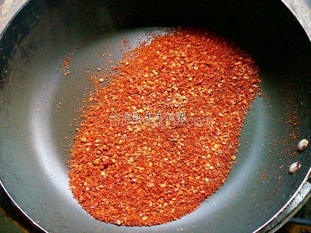 平底锅倒入适量辣椒粉，视个人吃辣程度加吧！不放油！小火煸炒出香味！

如果你的白芝麻是生的，就可以倒入和辣椒粉一起煸炒。